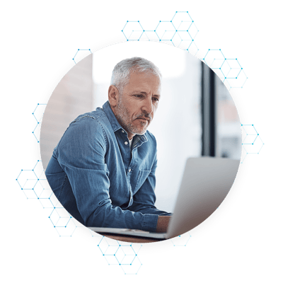 Man wearing blue button down shirt using computer in office